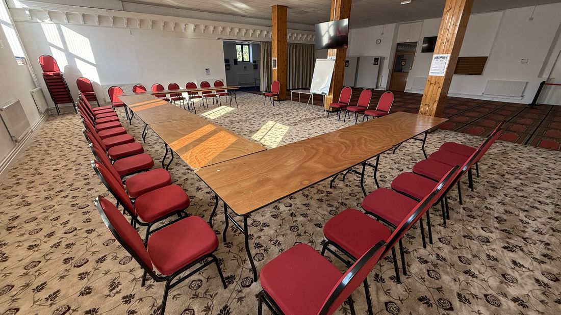 Venue set up in conference style with tables and chairs